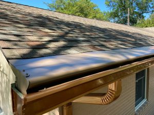 A close-up image of a guter cover system on a home with shingle roofing and k-style gutters.
